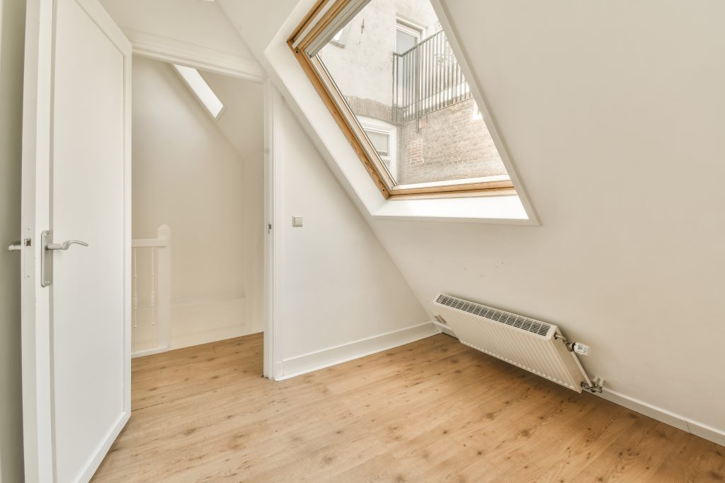 a loft conversion with a window and a wooden floor